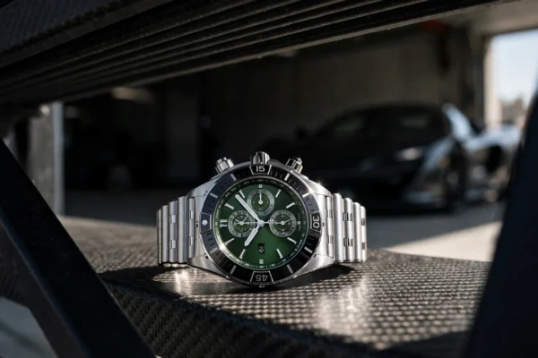 Cronógrafo Breitling Super Chronomat B19 44 sobre fibra de carbono, visto tras una puerta de garaje con sol duro