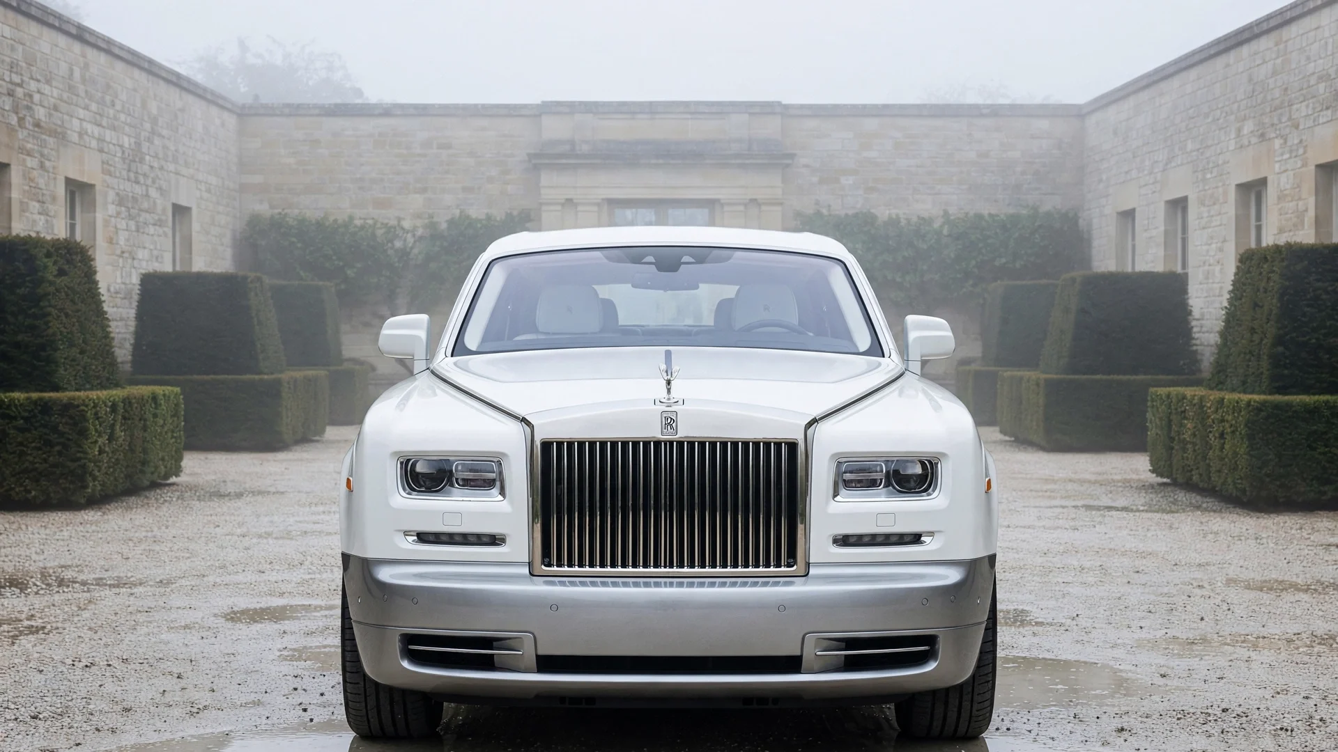 Rolls-Royce Phantom blanco de frente en un patio de piedra caliza bajo luz nublada